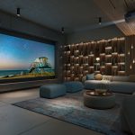 A modern home theater with a large projection screen displaying a scenic beach and starry sky, surrounded by acoustic treatments, and a cozy seating area.